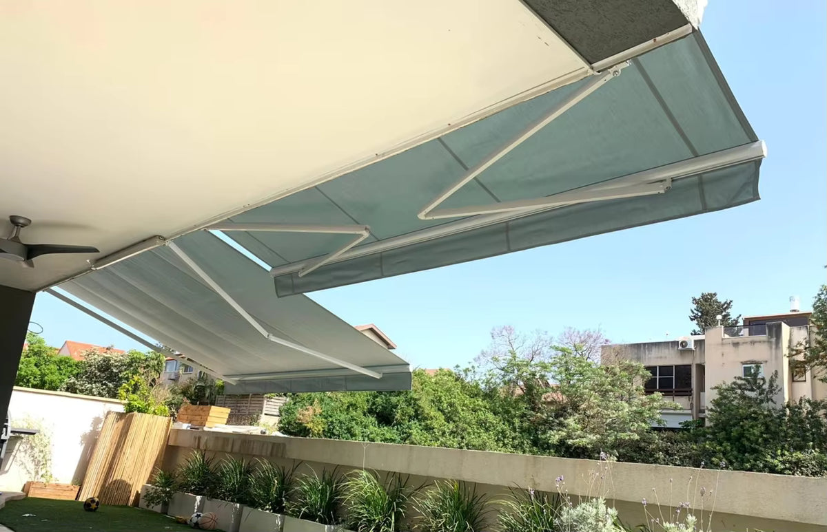 Toldo proyectante extendido visto desde abajo en balcon con vista al jardin