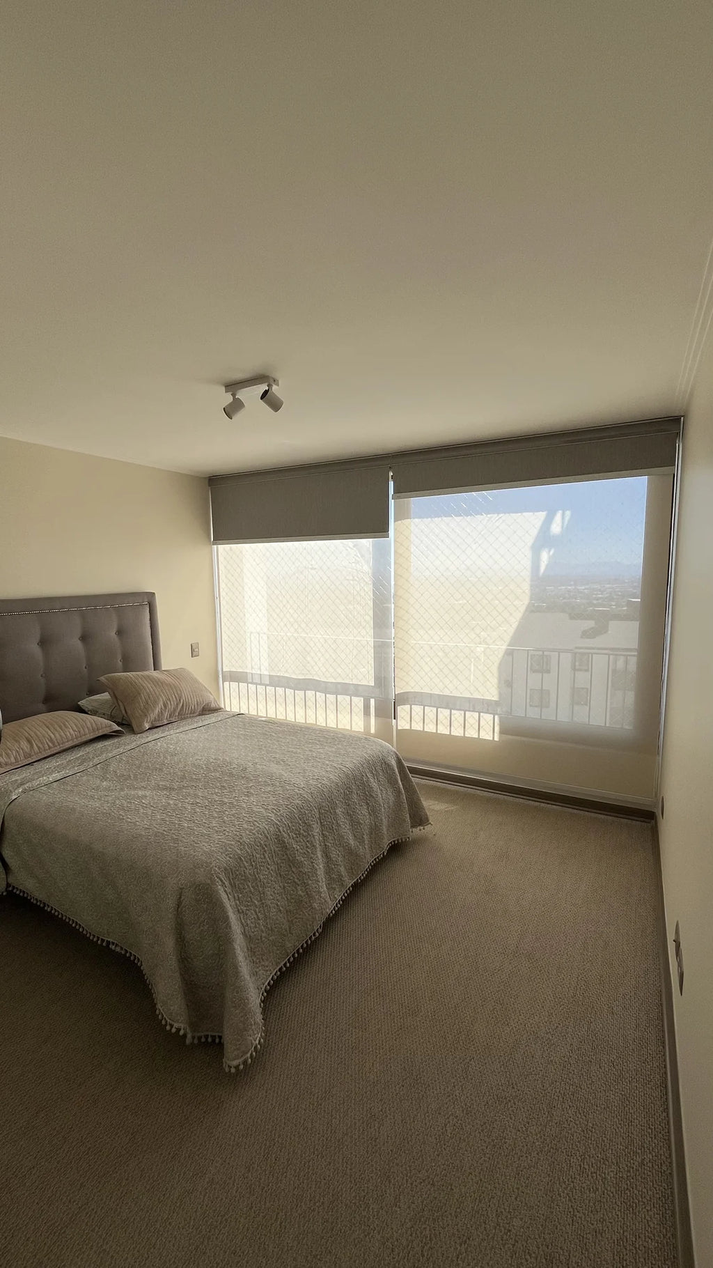 Cortina roller doble con blackout y sunscreen instalada en ventanal de dormitorio