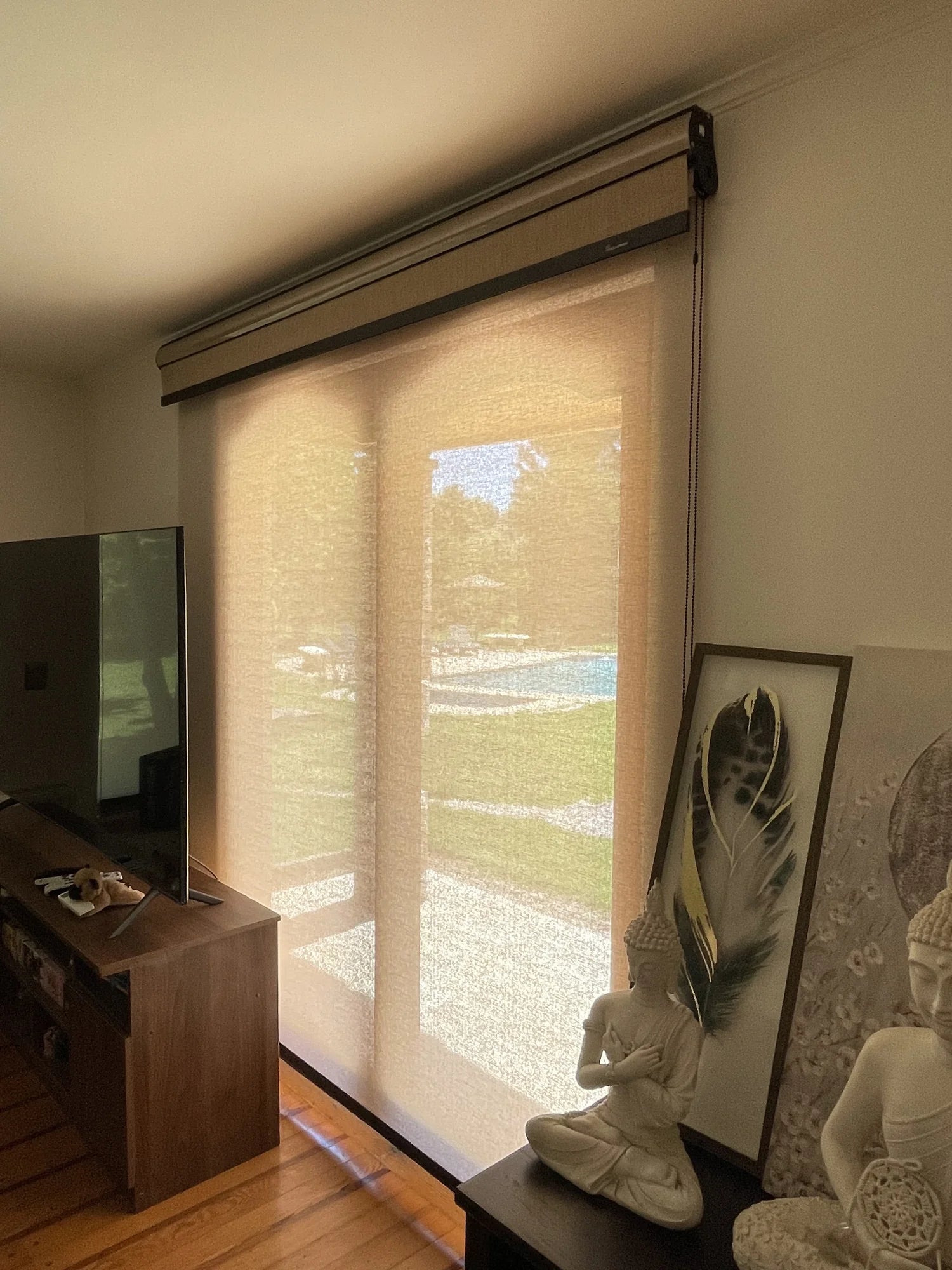 Cortina roller doble con tela sunscreen beige instalada en ventanal de living