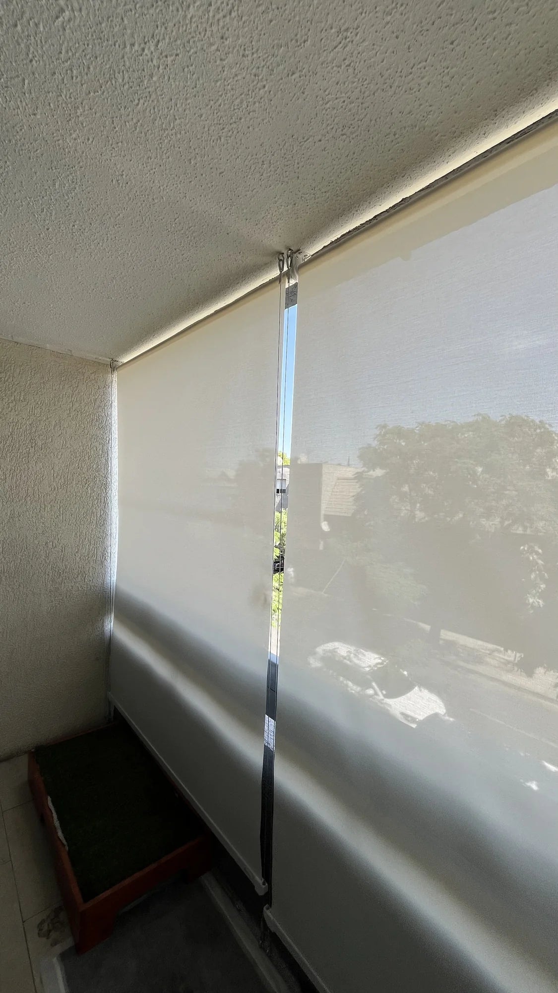 Toldo vertical con tela screen blanca cerrado en terraza de departamento
