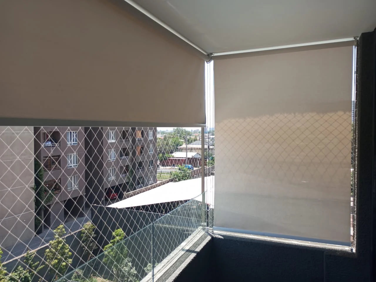 Toldos verticales con tela screen beige instalados en terraza de departamento