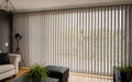 Cortina vertical beige en ventanal corredero de living